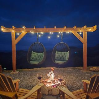 Fire pit aceso sob o varal de luzes